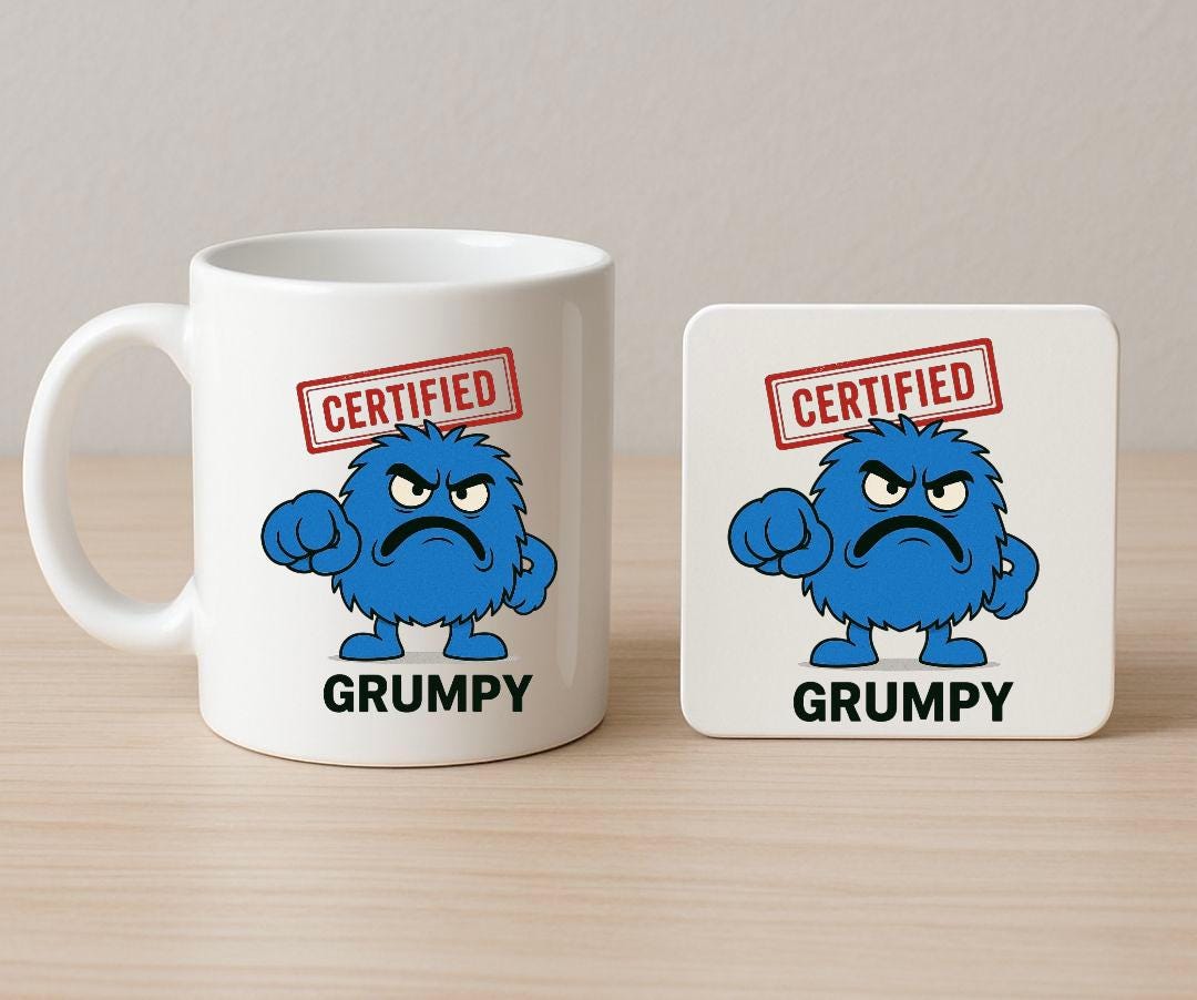 A mug and Coaster with a Blue Furry Cartoon Character with a grumpy expression. certified red stamp above the charaters head and big bold grumpy bold text at the bottom of the mug